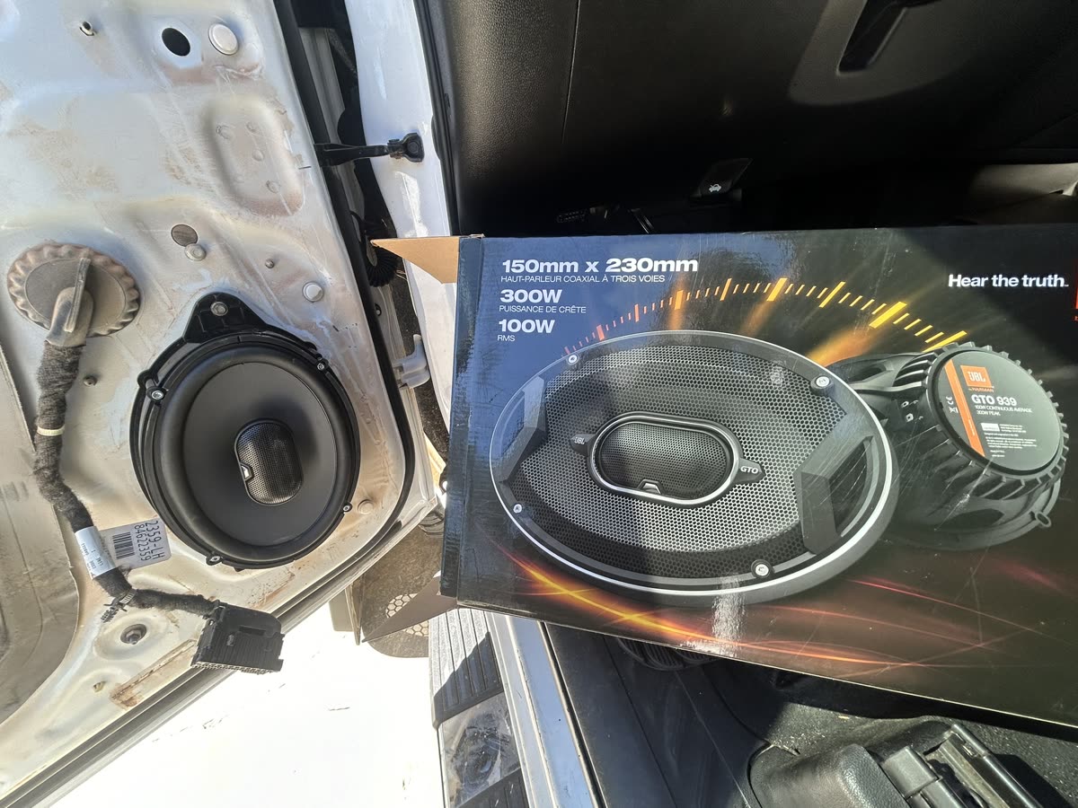JBL speaker box next to an open door with the new speaker installed