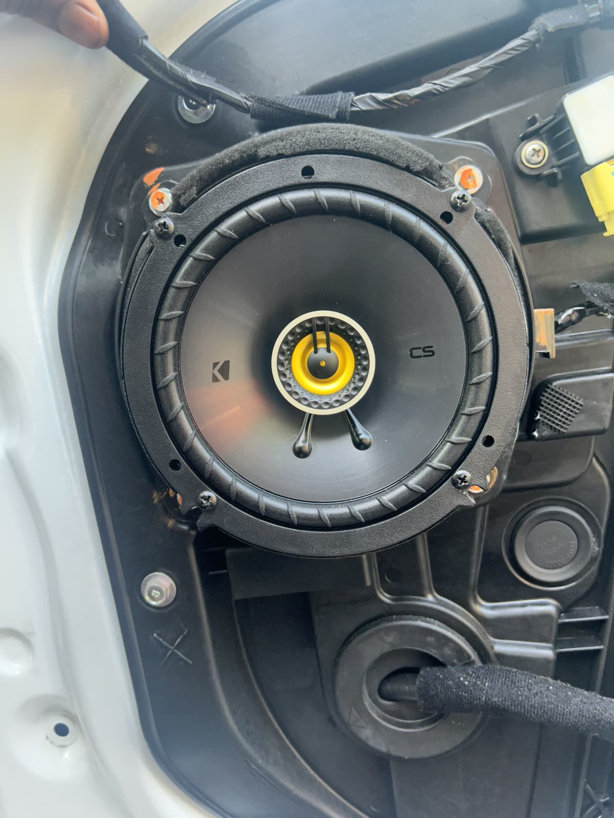 Kicker coaxial speaker with the tweeter in the center, installed in a factory door